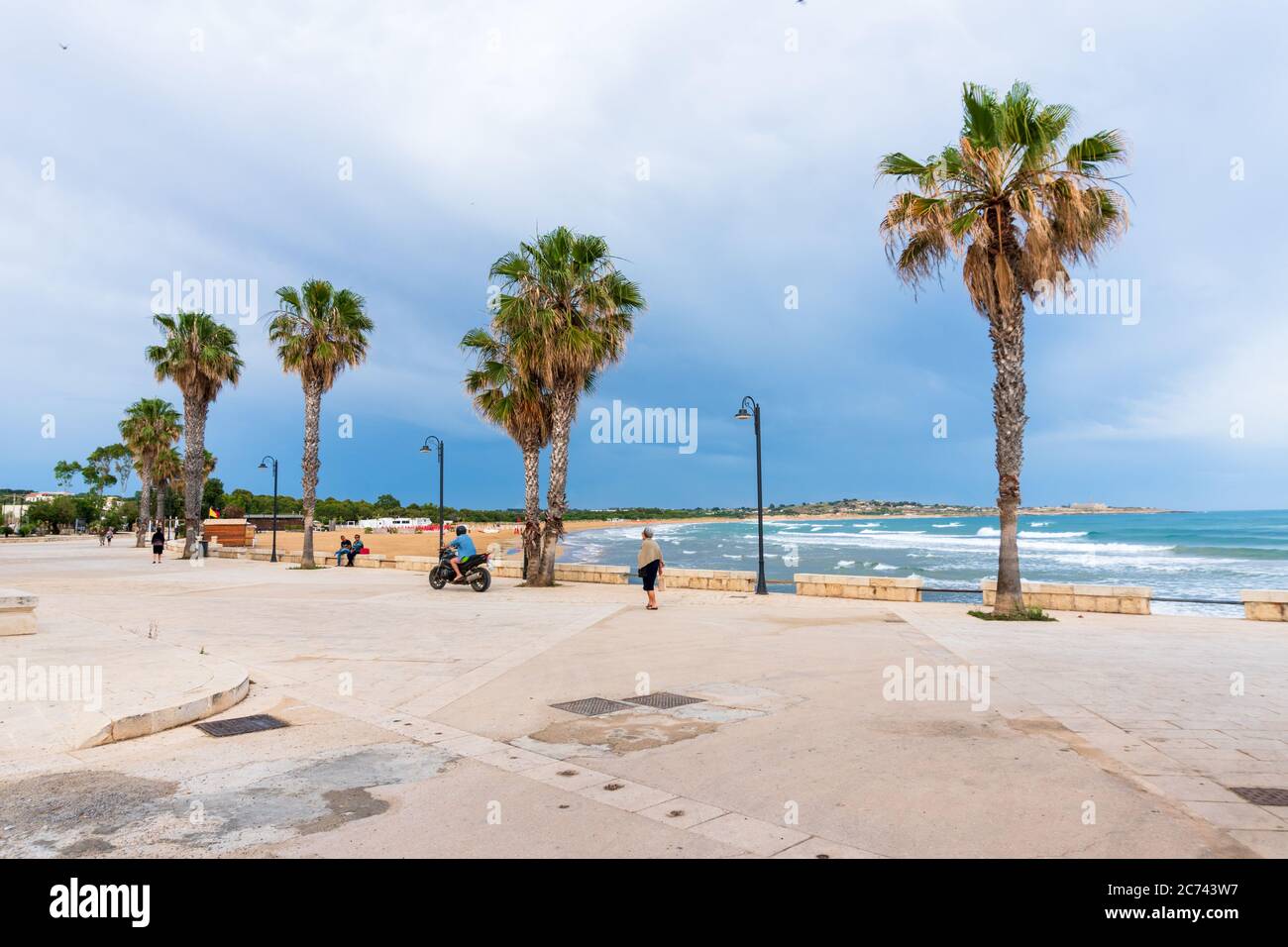 Strand und Strandpromenade in Sampieri Sizilien im Licht eines abziehenden Unwetters Foto Stock