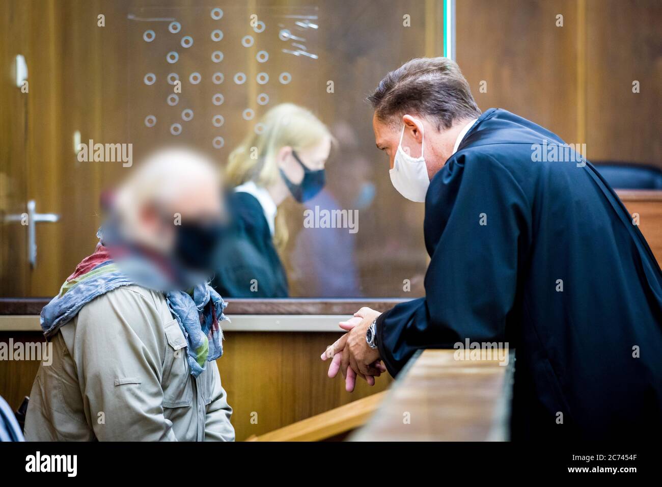 Hannover, Germania. 14 luglio 2020. Un ex poliziotto accusato (l) consulta il suo avvocato difensivo Matthias Steppuhn (r) in una sala del tribunale regionale all'inizio del processo. Si dice che l'uomo, che è stato un ufficiale della sede della polizia dal settembre 2014 al dicembre 2016, abbia lavorato come detective privato dalla parte, offrendo informazioni interne a terzi. Credit: Moritz Frankenberg/dpa - ATTENZIONE: Il convenuto è stato pixelated da ordine del tribunale/dpa/Alamy Live News Foto Stock