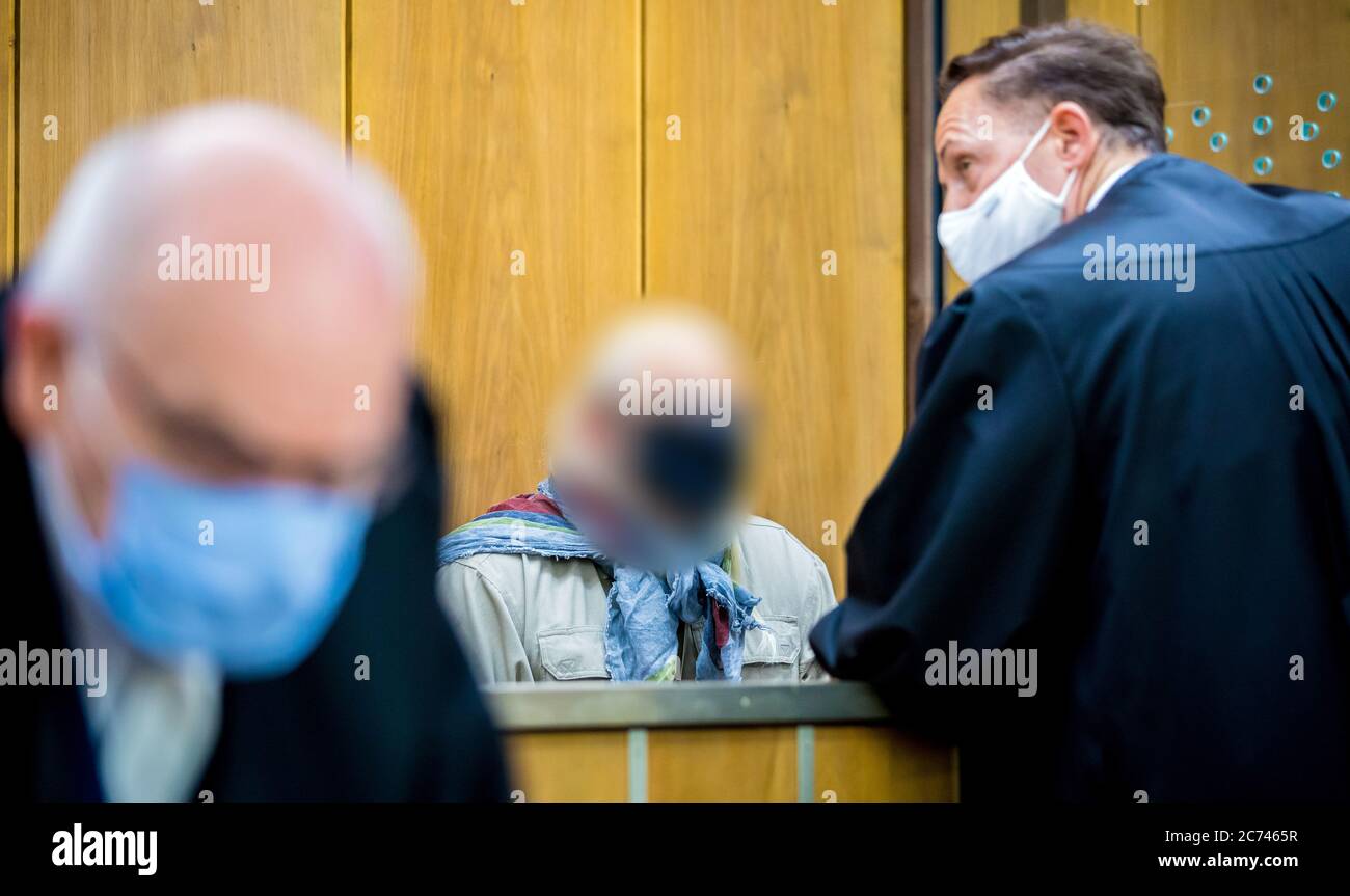 Hannover, Germania. 14 luglio 2020. Un ex poliziotto accusato (M) consulta il suo avvocato difensivo Matthias Steppuhn (r) in una sala del tribunale regionale all'inizio del processo. Si dice che l'uomo, che è stato un ufficiale della sede della polizia dal settembre 2014 al dicembre 2016, abbia lavorato come detective privato dalla parte, offrendo informazioni interne a terzi. Credit: Moritz Frankenberg/dpa - ATTENZIONE: Il convenuto è stato pixelated da ordine del tribunale/dpa/Alamy Live News Foto Stock