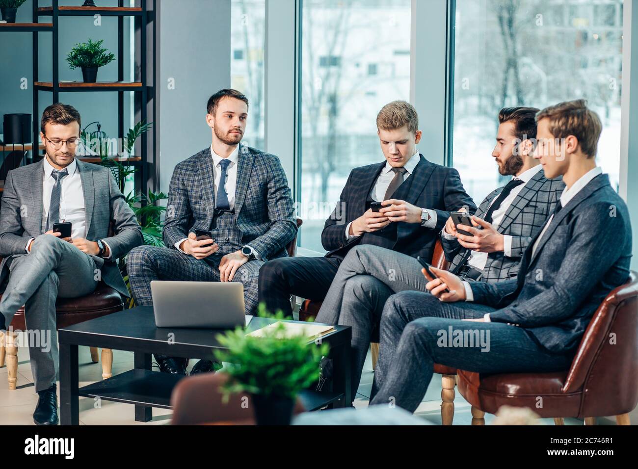 gruppo di giovani uomini d'affari si sono riuniti per discutere strategie aziendali e nuove idee, lavoro coorking in moderna sala di consiglio esecutivo, tutti Foto Stock