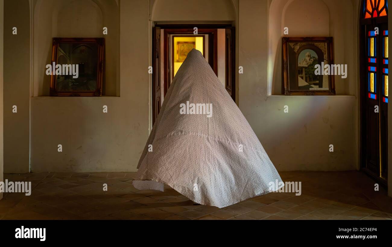 Kashan, Iran - Maggio 2019: Donna iraniana non identificata in Chador hijab camminando all'interno della Casa storica di Tabatabaei Natanzi Khaneh Foto Stock