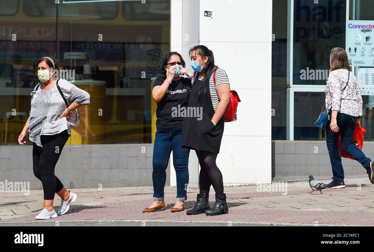 Brighton UK 14 luglio 2020 - acquirenti per le strade di Brighton indossando maschere di protezione oggi . Da venerdì 24 luglio sarà obbligatorio per le persone indossare maschere o rivestimenti all'interno di negozi in Inghilterra e potrebbero ricevere multe fino a £100 per non conformità . Le nuove regole sono state introdotte per aiutare nella battaglia contro il coronavirus COVID-19 pandemia: Credit Simon Dack / Alamy Live News Foto Stock