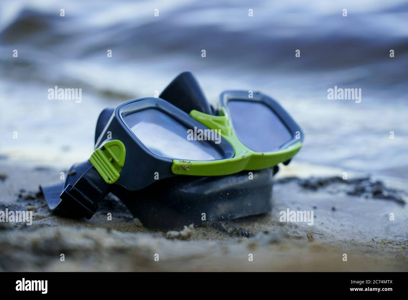 maschera per immersioni si trova sulla sabbia, la riva sullo sfondo dell'onda Foto Stock