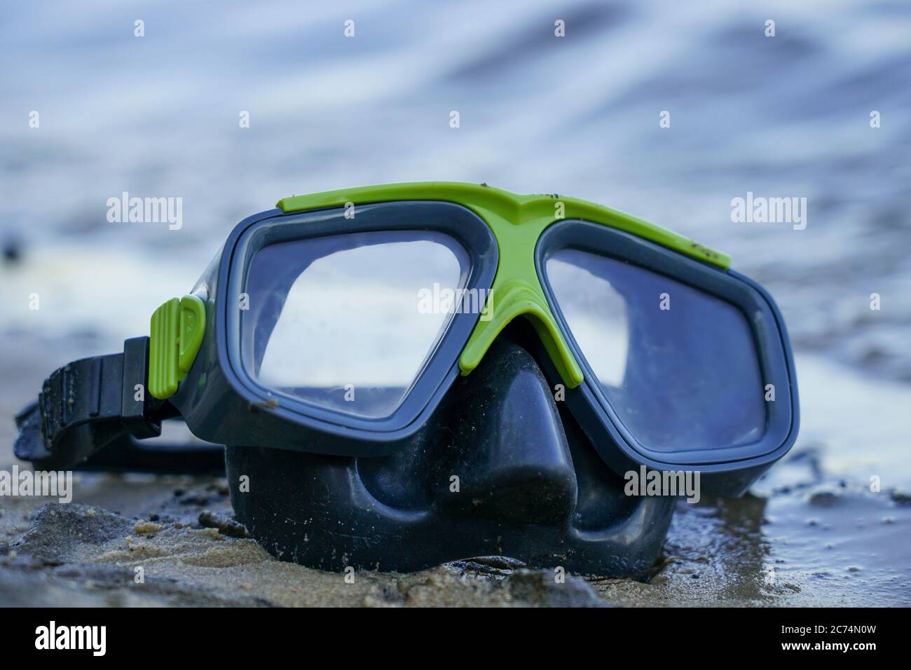 maschera per immersioni si trova sulla sabbia, la riva sullo sfondo dell'onda Foto Stock