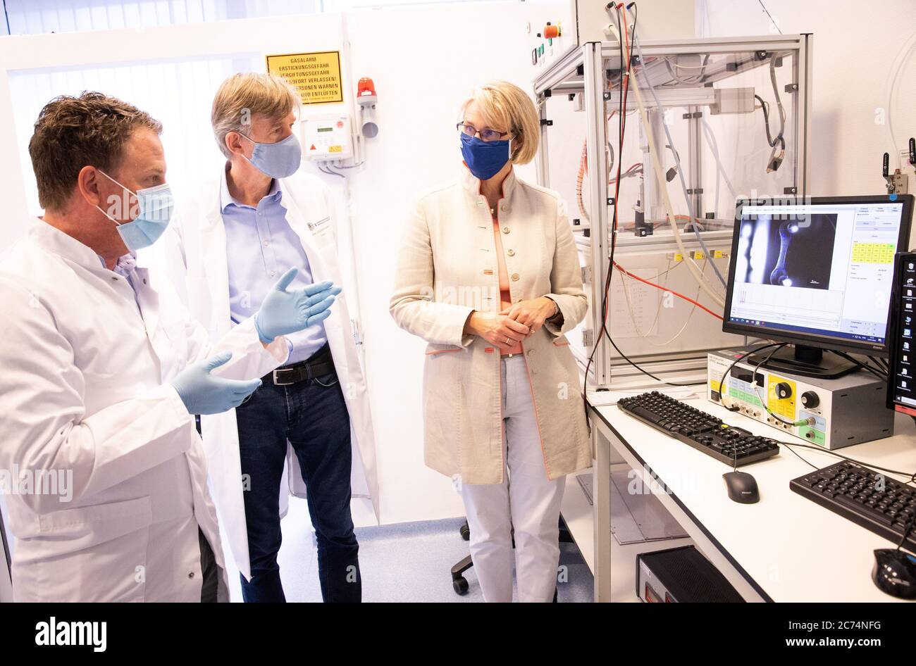 Amburgo, Germania. 14 luglio 2020. Anja Karliczek (CDU, r), Ministro federale dell'istruzione e della ricerca, visita il Centro medico universitario Hamburg-Eppendorf (UKE) per saperne di più da Thomas Eschenhagen, capo dell'Istituto di farmacologia sperimentale e tossicologia (IEPT), e Arne Hansen (l), in un laboratorio durante una dimostrazione di battitura di cellule muscolari cardiache artificiali. Credit: Christian Charisius/dpa/Pool/dpa/Alamy Live News Foto Stock