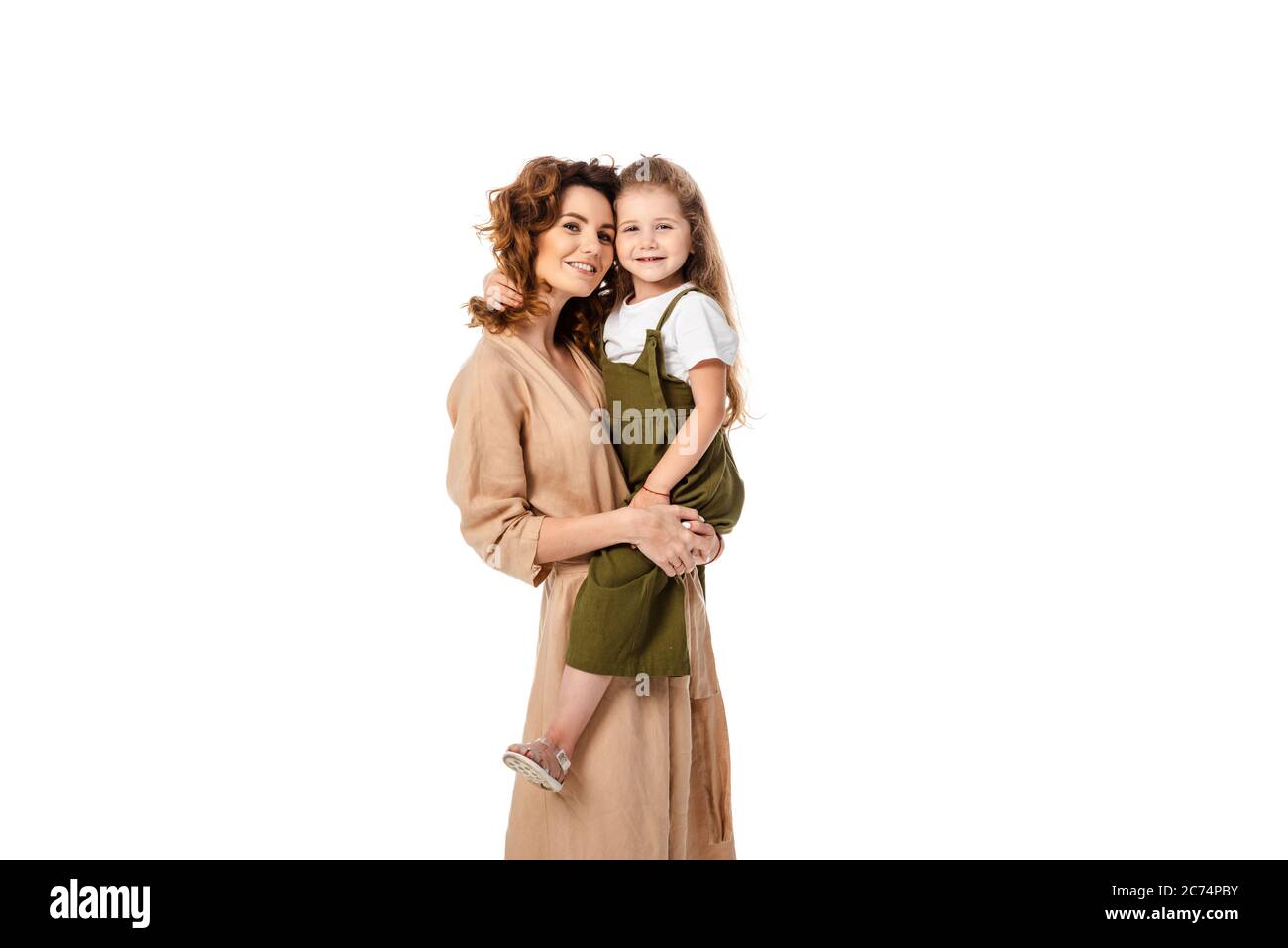 madre sorridente che tiene in braccio figlia isolata su bianco Foto Stock
