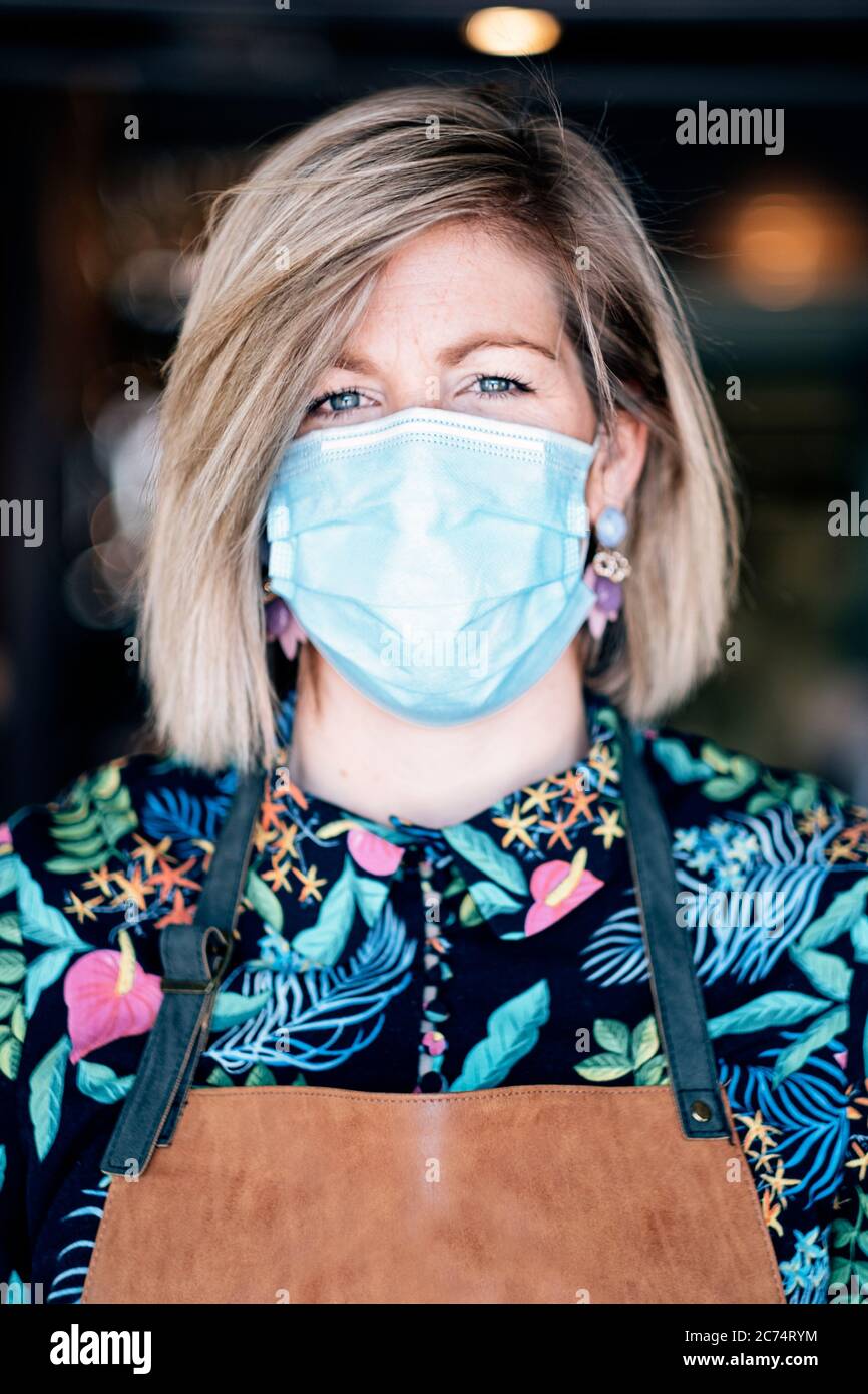 ritratto di una donna con grembiule che indossa una maschera protettiva contro il virus Foto Stock