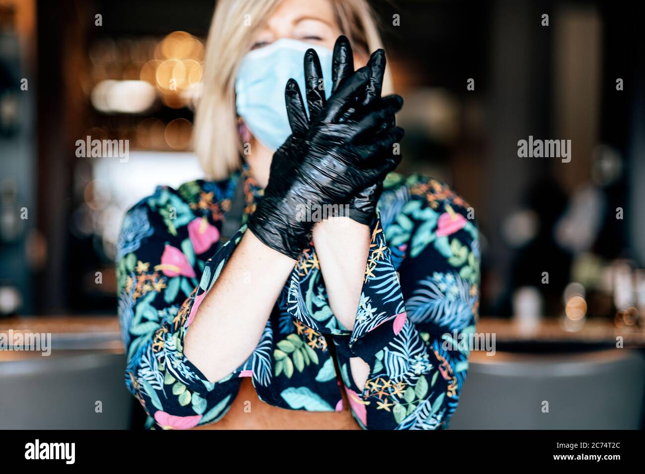il lavoratore del ristorante di takeaway del cibo si prepara a lavorare con i guanti, la maschera e il gel antisettico - protezioni di base nel tempo di scoppio del coronavirus Foto Stock