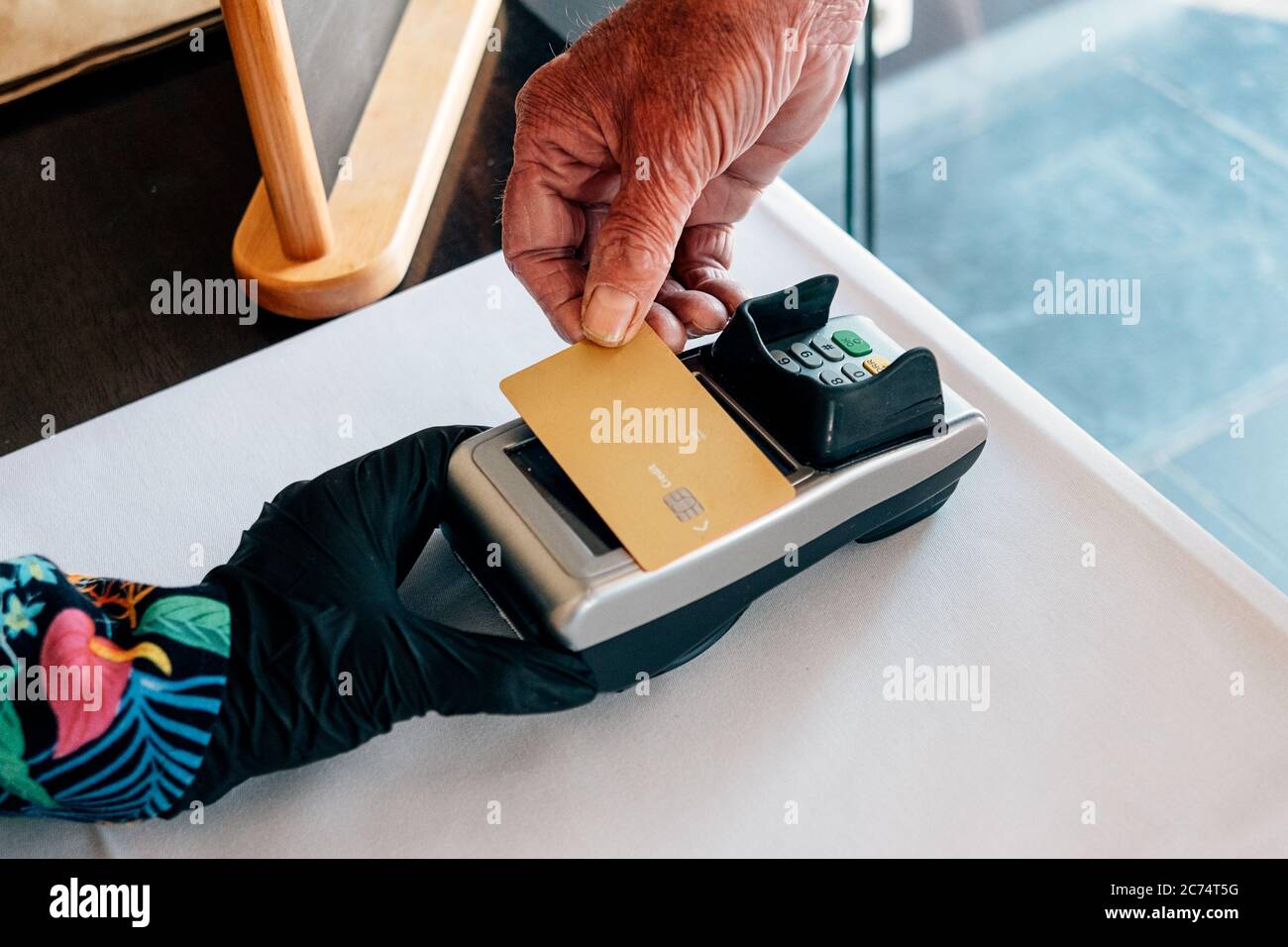 primo piano su vecchia carta di mano maschio per il pagamento elettronico sul terminale Foto Stock