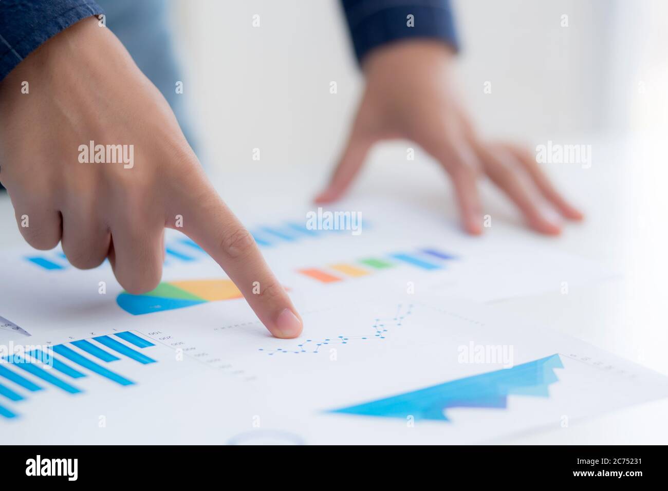Mano di giovane uomo d'affari che indica i dati del documento grafico e carta, marketing e investimenti, rapporto di statistiche utili per finanziario, economico Foto Stock
