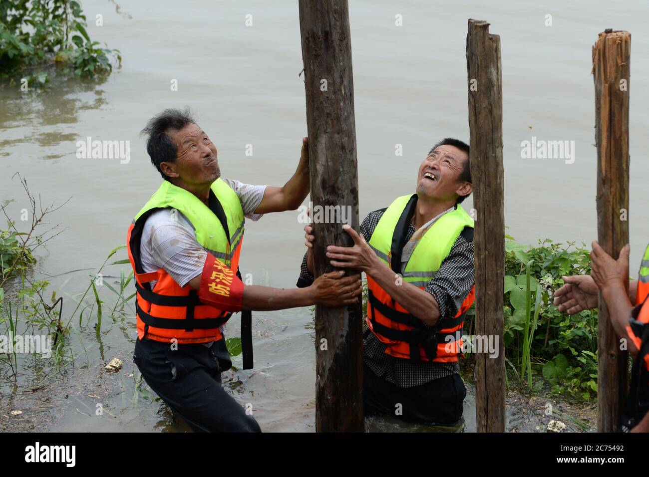 Zongyang, provincia cinese di Anhui. 14 luglio 2020. Gli abitanti del villaggio cercano di bloccare le tubature all'argine di un'isola fluviale nella cittadina di Changsha nella contea di Zongyang, nella provincia di Anhui, nella Cina orientale, il 14 luglio 2020. I funzionari locali e i residenti nella città di Changsha stanno combattendo contro le tubature fluviali-isolane innescate dalle crescenti acque del fiume Yangtze. Tutti i residenti sull'isola sono stati ricollocati in sicurezza. Credit: Huang Bohan/Xinhua/Alamy Live News Foto Stock
