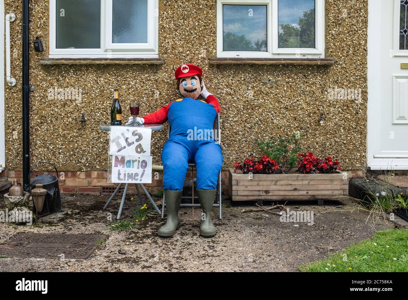 Lo scarrecrow di novità in mostra all'esterno della casa durante il festival annuale dello scarrecrow nel villaggio di Holwell, vicino a Hitchin, Hertfordshire. Foto Stock