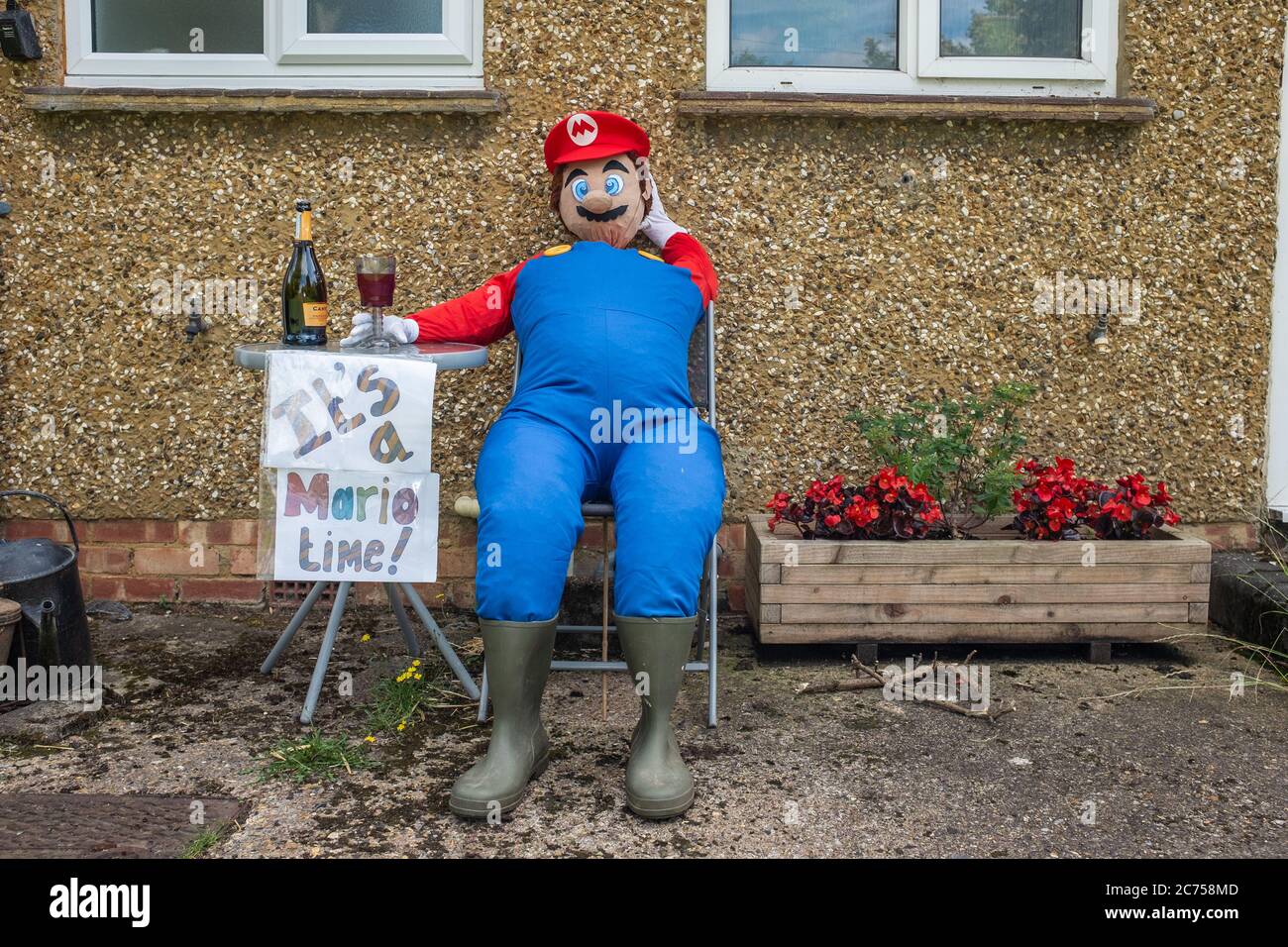 Lo scarrecrow di novità in mostra all'esterno della casa durante il festival annuale dello scarrecrow nel villaggio di Holwell, vicino a Hitchin, Hertfordshire. Foto Stock