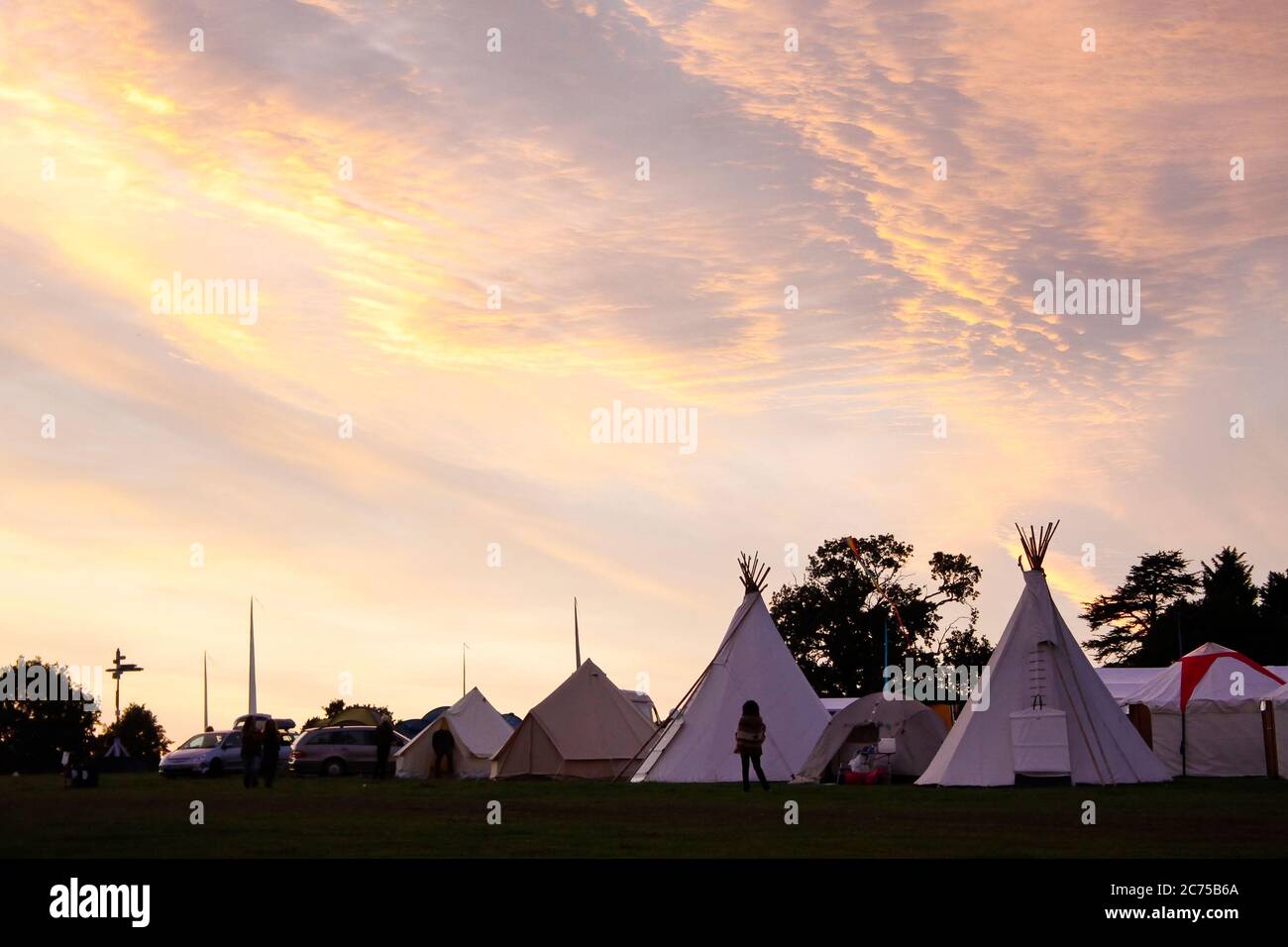 Tipis in campo glamping con ad un campeggio festival al tramonto, Norfolk Foto Stock
