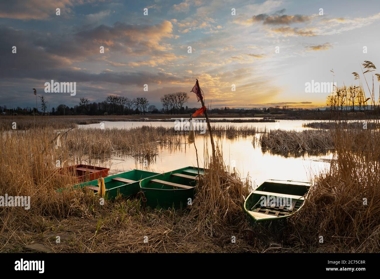 Barche da pesca sulla riva del lago e cielo nuvoloso sera Foto Stock