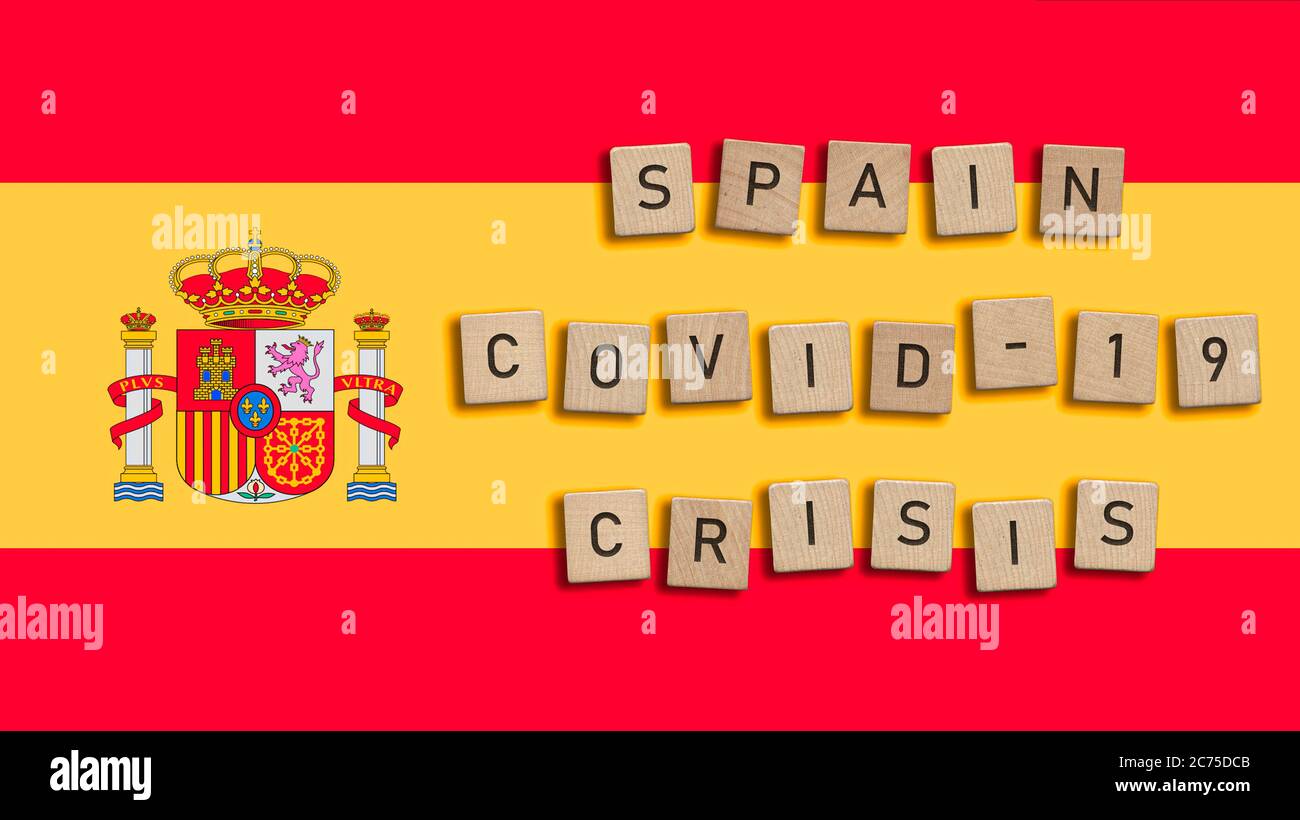 Spagna Covid 19 crisi scritta con piastrelle di legno su sfondo bandiera spagnola. Sindrome respiratoria coronavirus e nuovo coronavirus 2019-nCoV. Virus Foto Stock