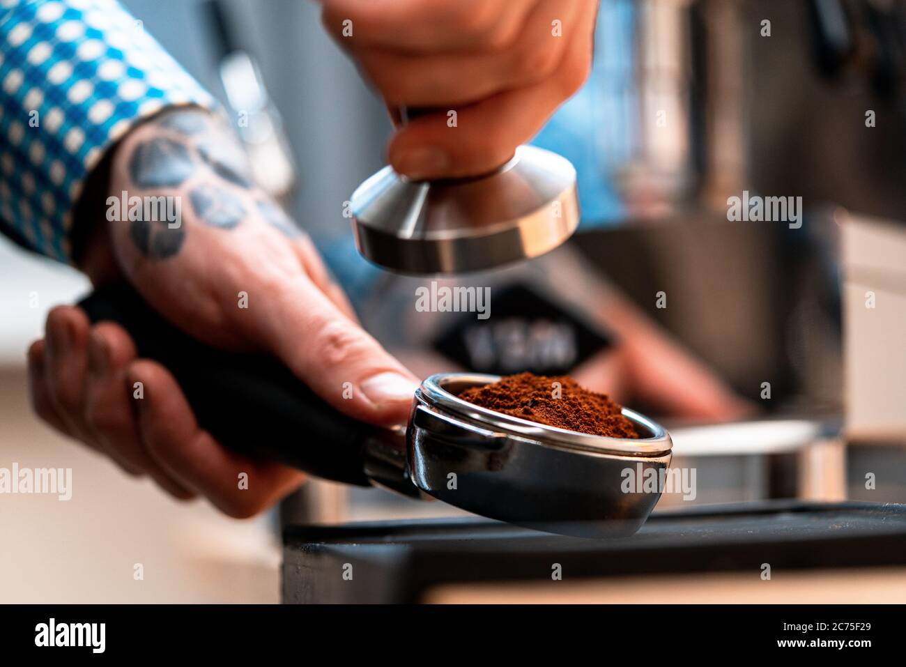 Primo piano del portafiltro Barista Hands Holding con caffè macinato. Preparazione del caffè a casa. Buon caffè senza lasciare casa Foto Stock