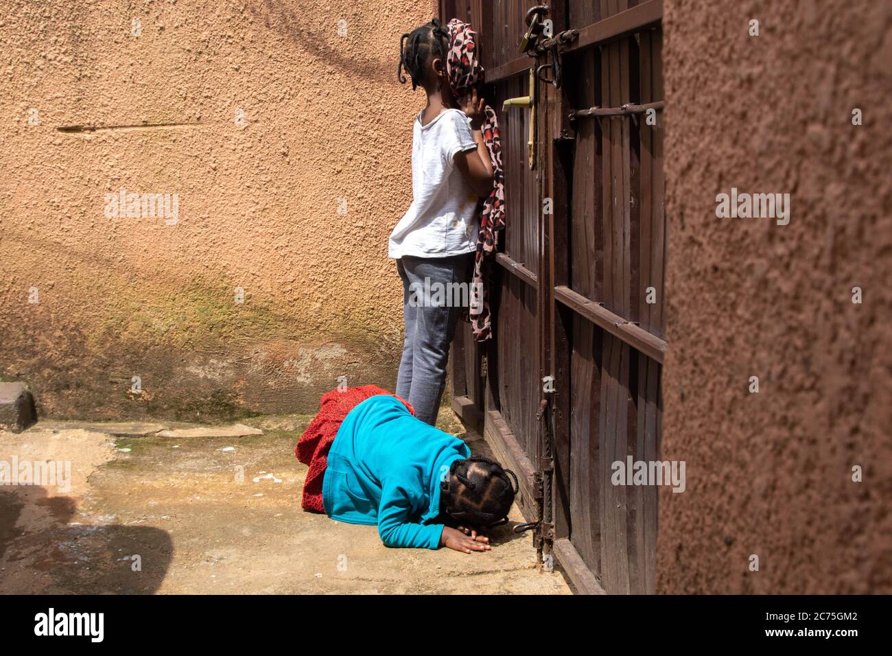 Barbie e Amilia sono sempre curiosi di sapere cosa sta succedendo all'esterno. Sono in blocco a causa del Coronavirus. Karugira, Kigali, Ruanda. Foto Stock