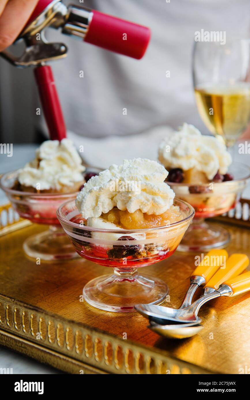 Dessert con frutta e panna montata in preparazione Foto Stock