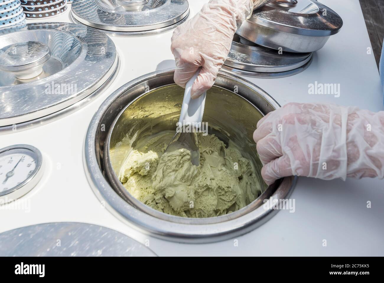 chef che mescola il pistacchio icecream in una ciotola inox Foto Stock