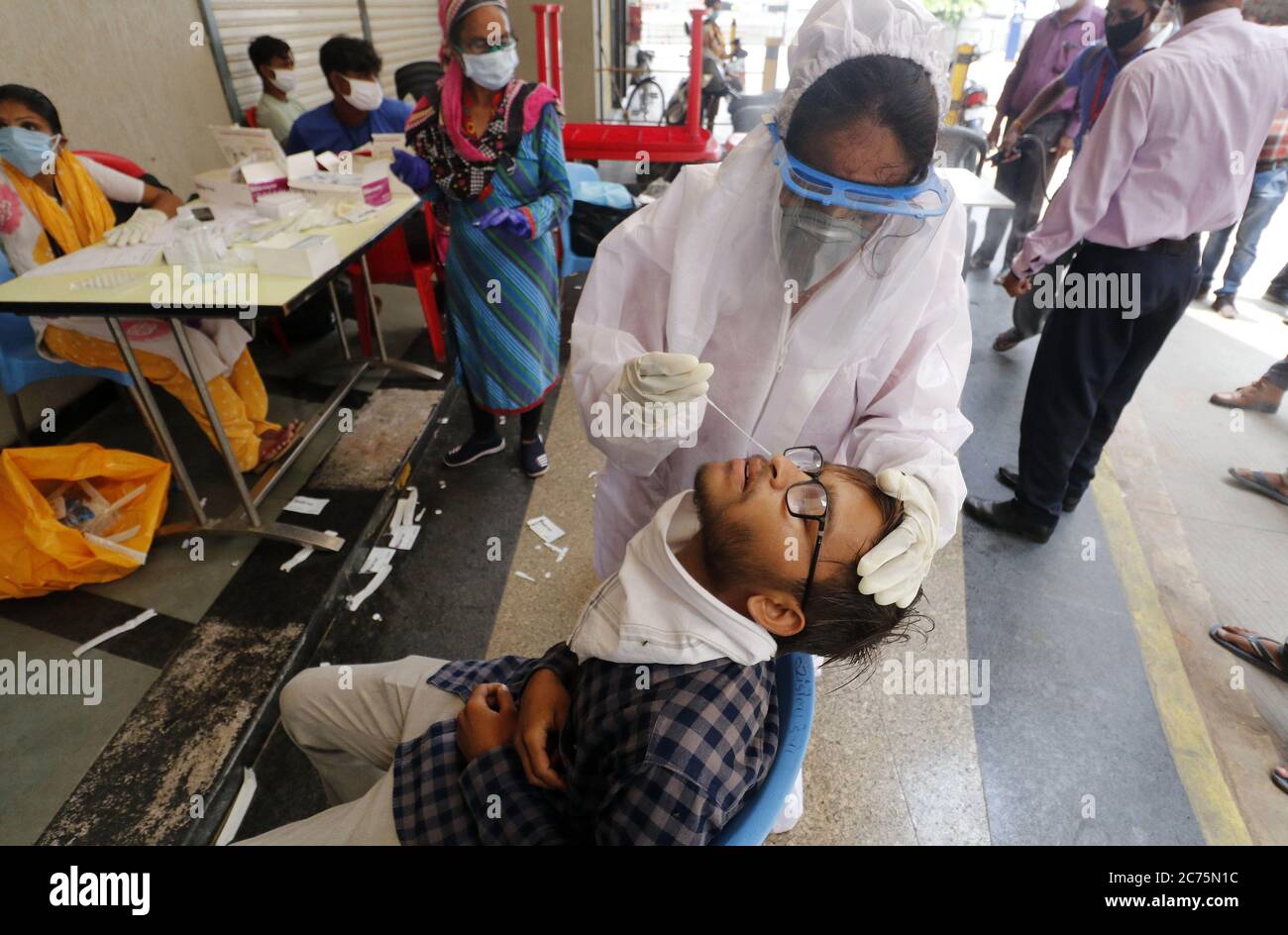 Nuova Delhi, India. 14 luglio 2020. Un operatore sanitario prende un campione da un uomo presso un terminal di autobus a Ahmedabad, India, il 14 luglio 2020. Il numero totale di casi COVID-19 in India ha superato il 900,000-mark Martedì, raggiungendo 906,752, con i decessi totali in piedi a 23,727, ha detto gli ultimi dati emessi dal ministero federale della salute. Credit: Sr/Xinhua/Alamy Live News Foto Stock