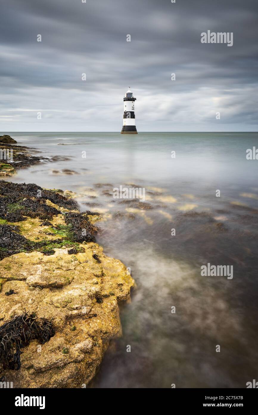 Trwyn Du Faro Penmon punto, Anglesey, è circondato da una marea crescente su un nuvoloso pomeriggio come flusso di nuvole in cielo dietro. Foto Stock Trwyn Du Faro Penmon punto, Anglesey, è circondato da una marea crescente su un nuvoloso pomeriggio come flusso di nuvole in cielo dietro. Foto Stock