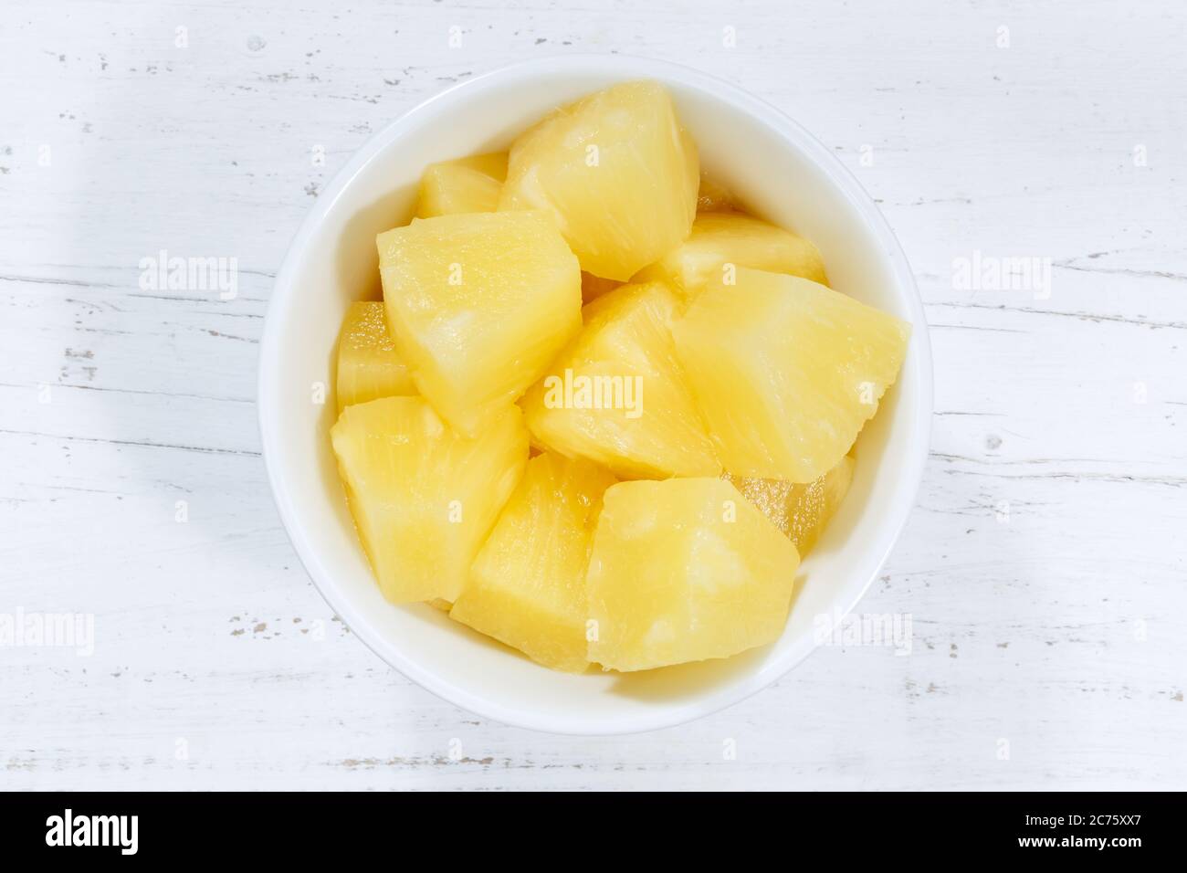 L'ananas cita la frutta da sopra il recipiente su un legno di legno Foto Stock