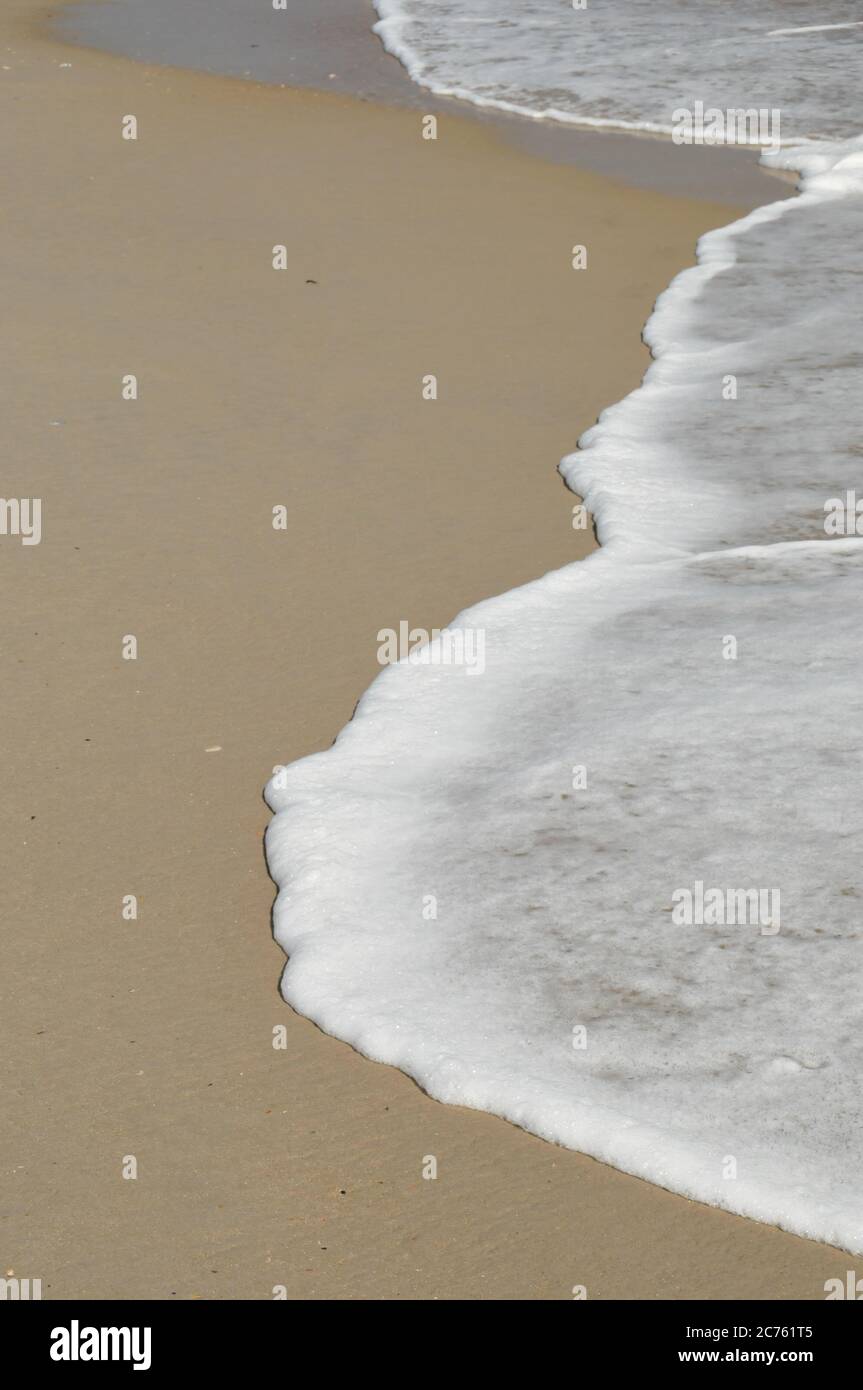 L'oceano si lambe su una spiaggia di sabbia con ampio spazio per la copia Foto Stock