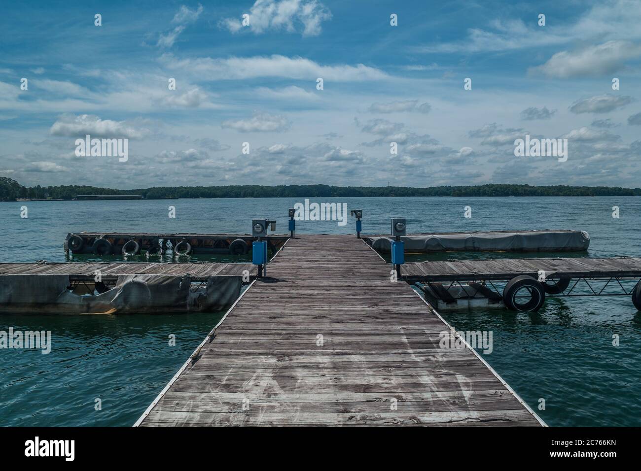 Vecchi e stagni bacini galleggianti in legno vuoti ma ha ancora servizio elettrico a loro al lago in una giornata di sole in estate Foto Stock