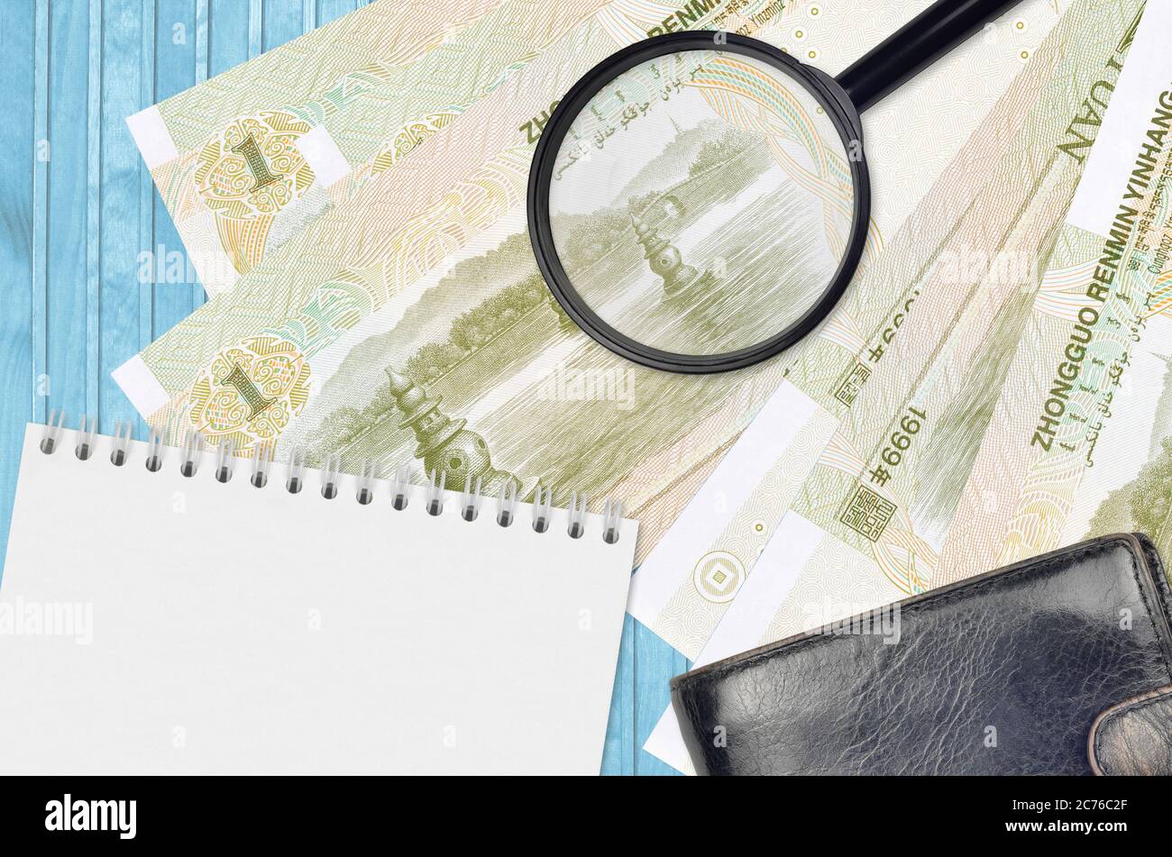 1 botole cinesi e lente d'ingrandimento con borsetta nera e blocco note. Concetto di denaro contraffatto. Cerca le differenze nei dettagli sulle bollette di denaro Foto Stock