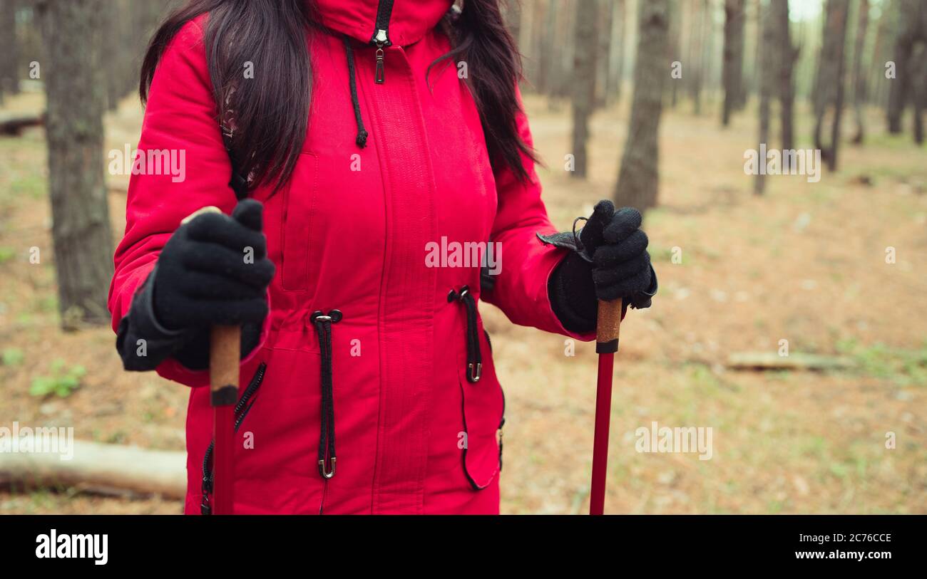 Una giovane donna è impegnata nel nordic walking in boschi. Foto Stock