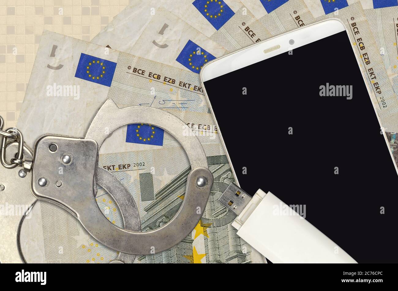 bollette da 5 euro e smartphone con polsini. Concetto di attacchi di phishing da parte di hacker, truffa illegale o distribuzione online di software spyware Foto Stock