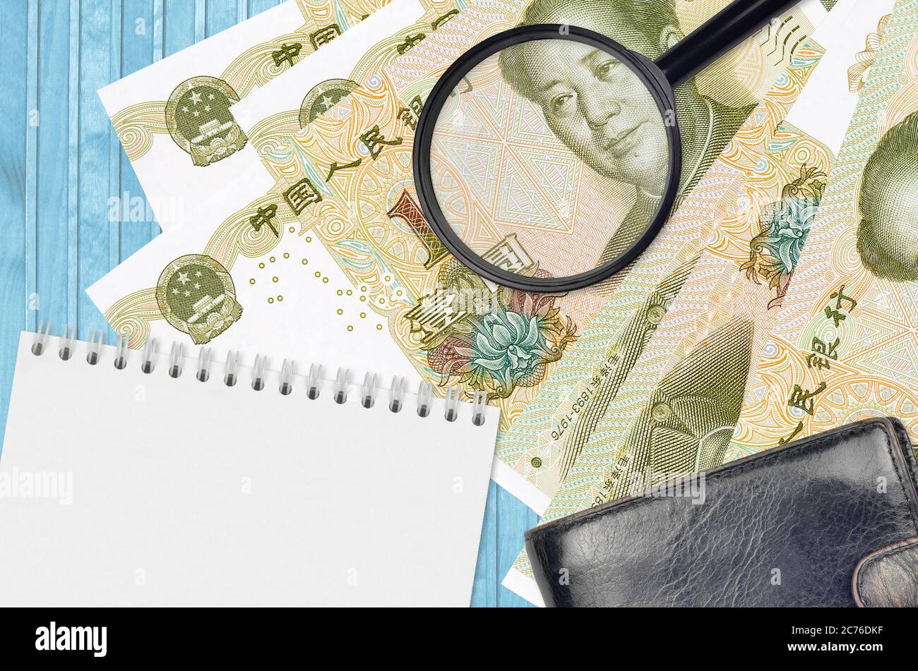 1 botole cinesi e lente d'ingrandimento con borsetta nera e blocco note. Concetto di denaro contraffatto. Cerca le differenze nei dettagli sulle bollette di denaro Foto Stock