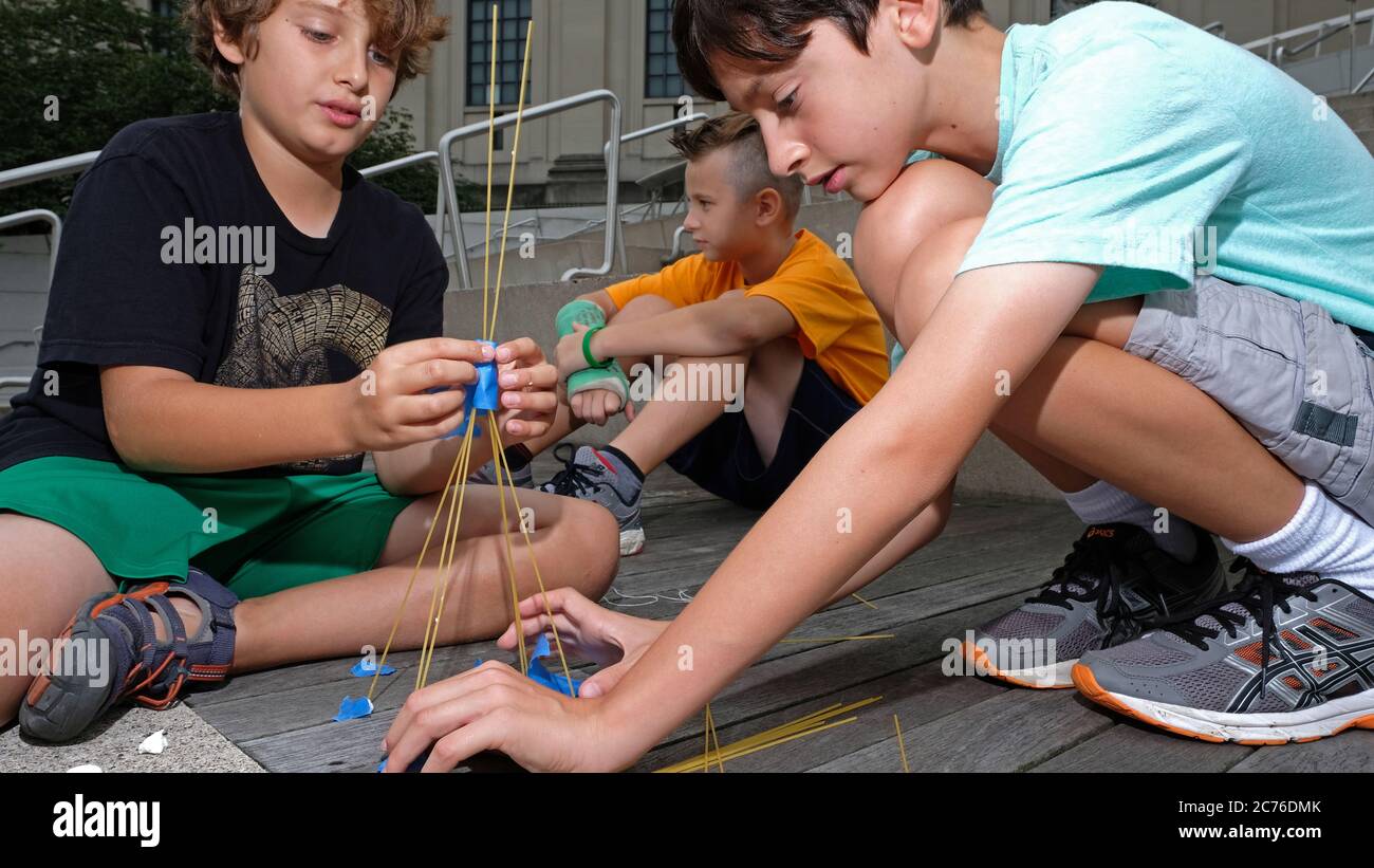 Giorno Camp, Brooklyn, New York City. I bambini costruiscono torri dagli spaghetti per imparare a conoscere il lavoro di squadra e l'equilibrio. Modello rilasciato. Foto Stock