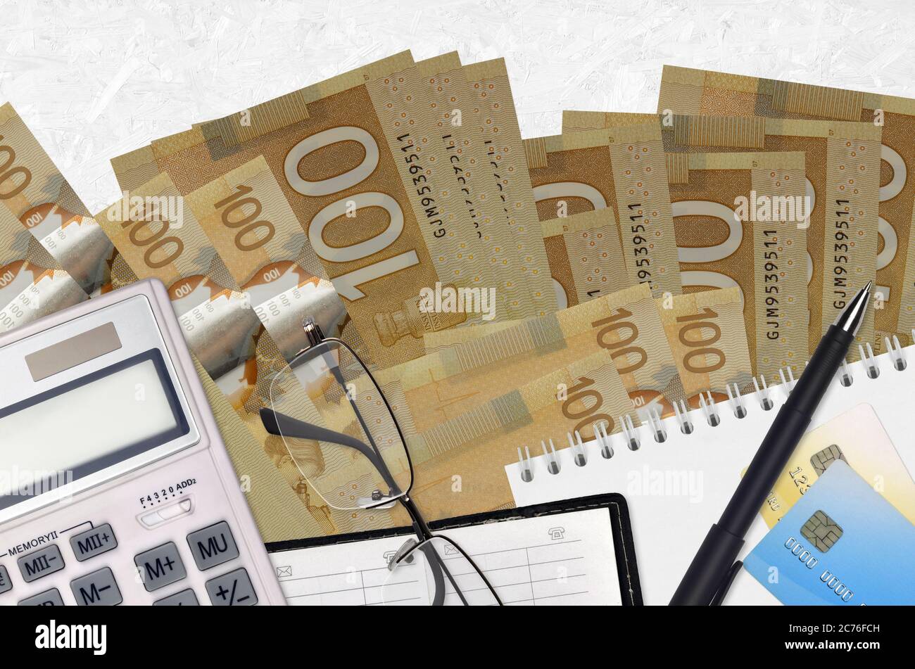 100 dollari canadesi bollette e calcolatrice con occhiali e penna. Concetto di stagione di pagamento fiscale o soluzioni di investimento. Pianificazione finanziaria o contabile p Foto Stock