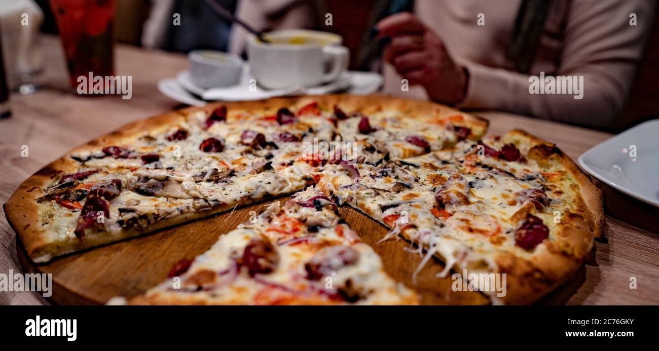 Pizza. Deliziosa pizza calda sul tavolo nel caffè Foto Stock