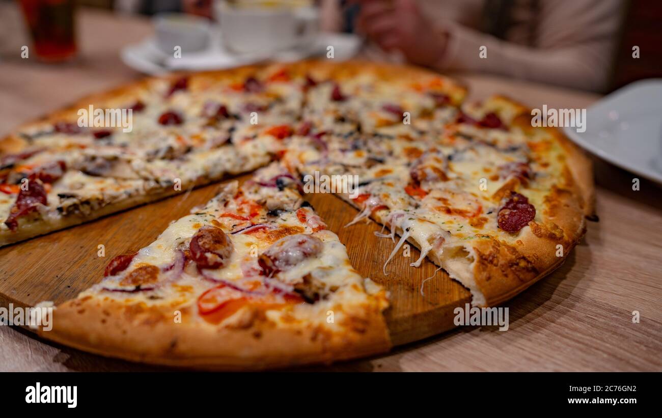 Pizza. Deliziosa pizza calda sul tavolo nel caffè Foto Stock