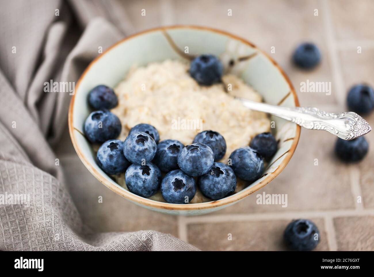 Primo piano di porridge di farinata d'avena con mirtilli freschi per colazione Foto Stock