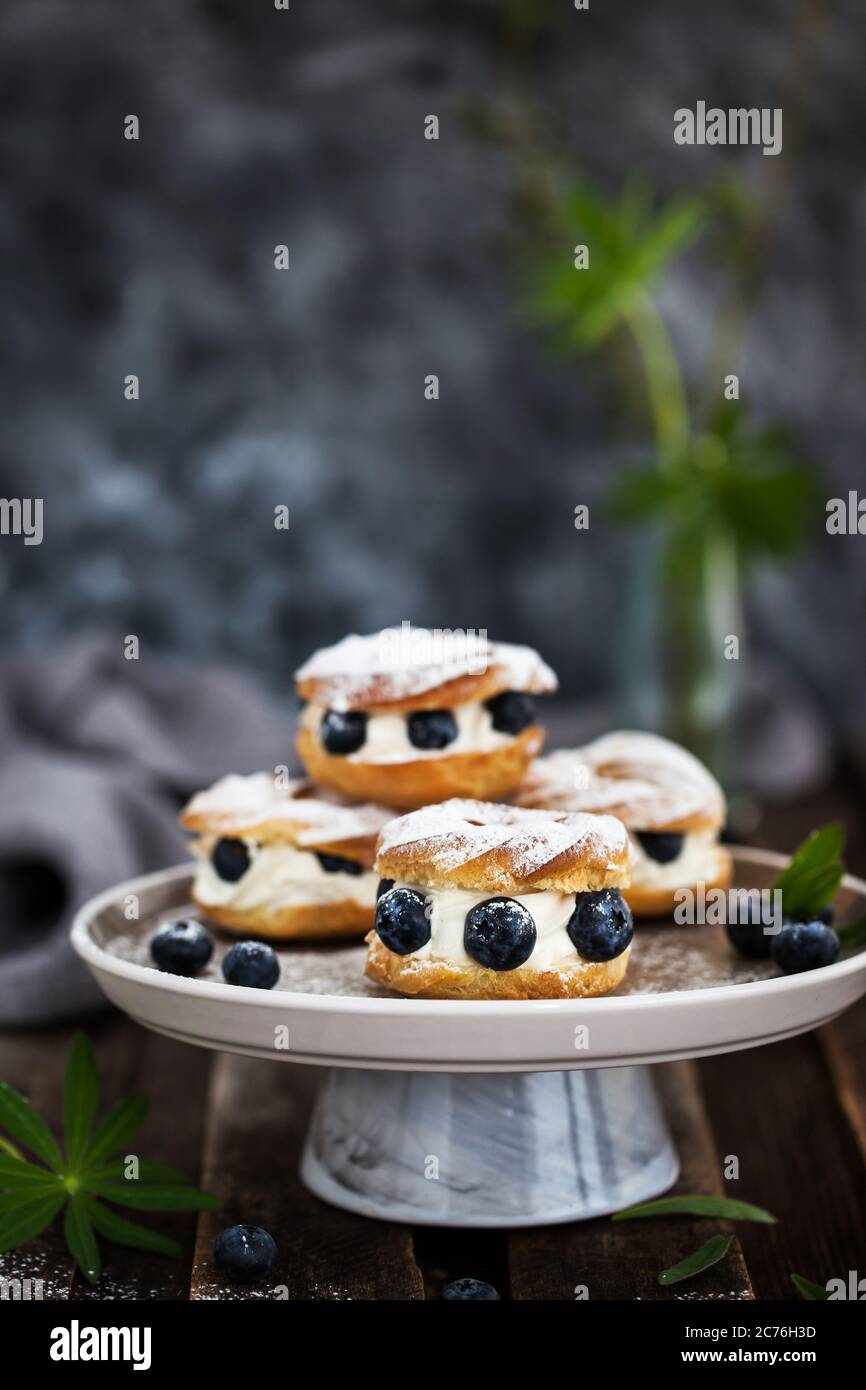 Anelli di sfoglia (pasta choux) decorati con mirtilli freschi Foto Stock