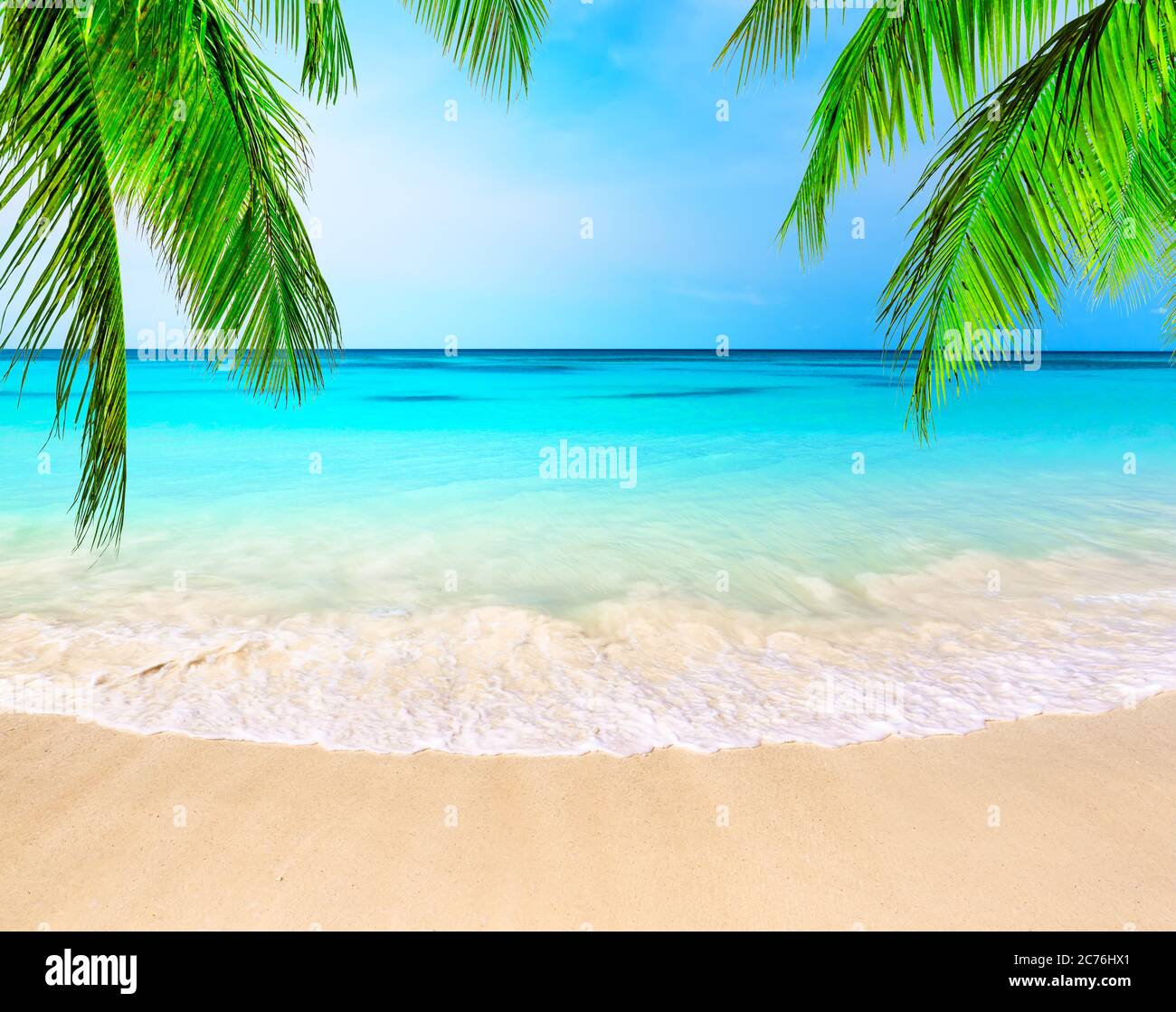 Palme da cocco contro il cielo blu e la bellissima spiaggia di Punta Cana, Repubblica Dominicana. Sfondo vacanze. Vista di un bel tropico Foto Stock