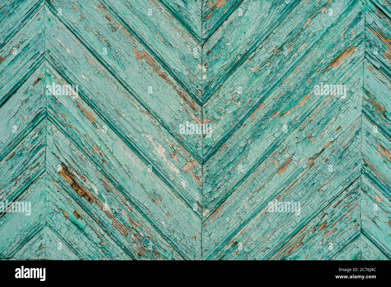Superficie in legno con vernice sgretolante. Sfondo testurizzato di vecchia superficie di legname con briciole di vernice turchese all'esterno dell'edificio shabby Foto Stock
