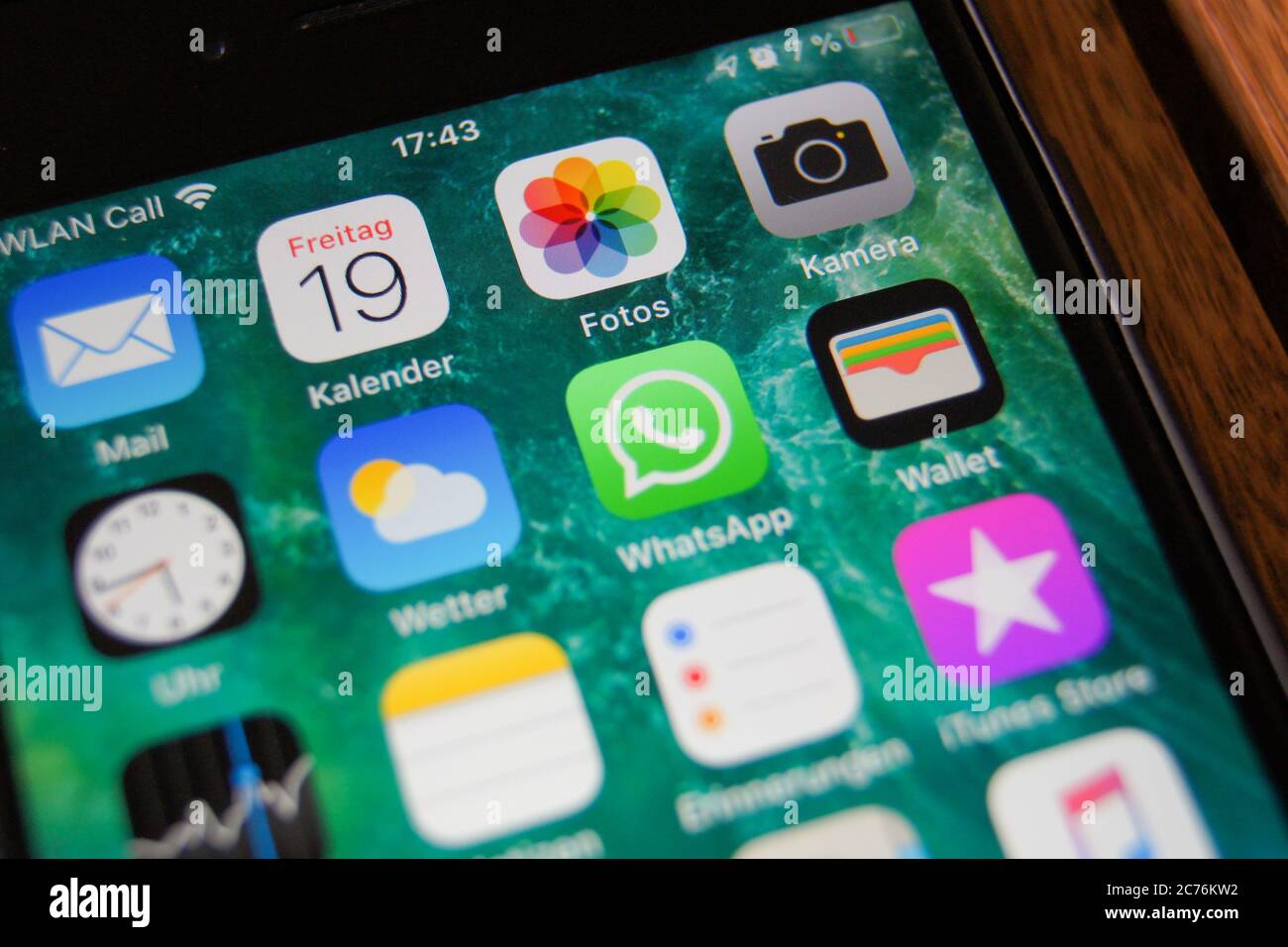 Primo piano della schermata iniziale di un iPhone Apple con icone di applicazioni come Mail, fotocamera, Foto, WhatsApp, Meteo, Orologio, azioni, portafoglio, Contatti e Musica. Foto Stock
