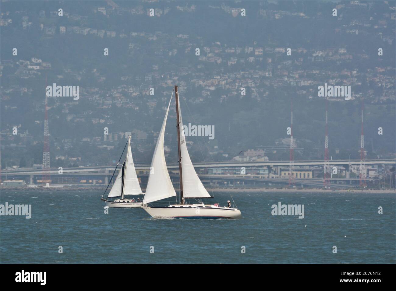 2 barche a vela sulla baia di San Francisco con Berkeley Oakland sullo sfondo Foto Stock