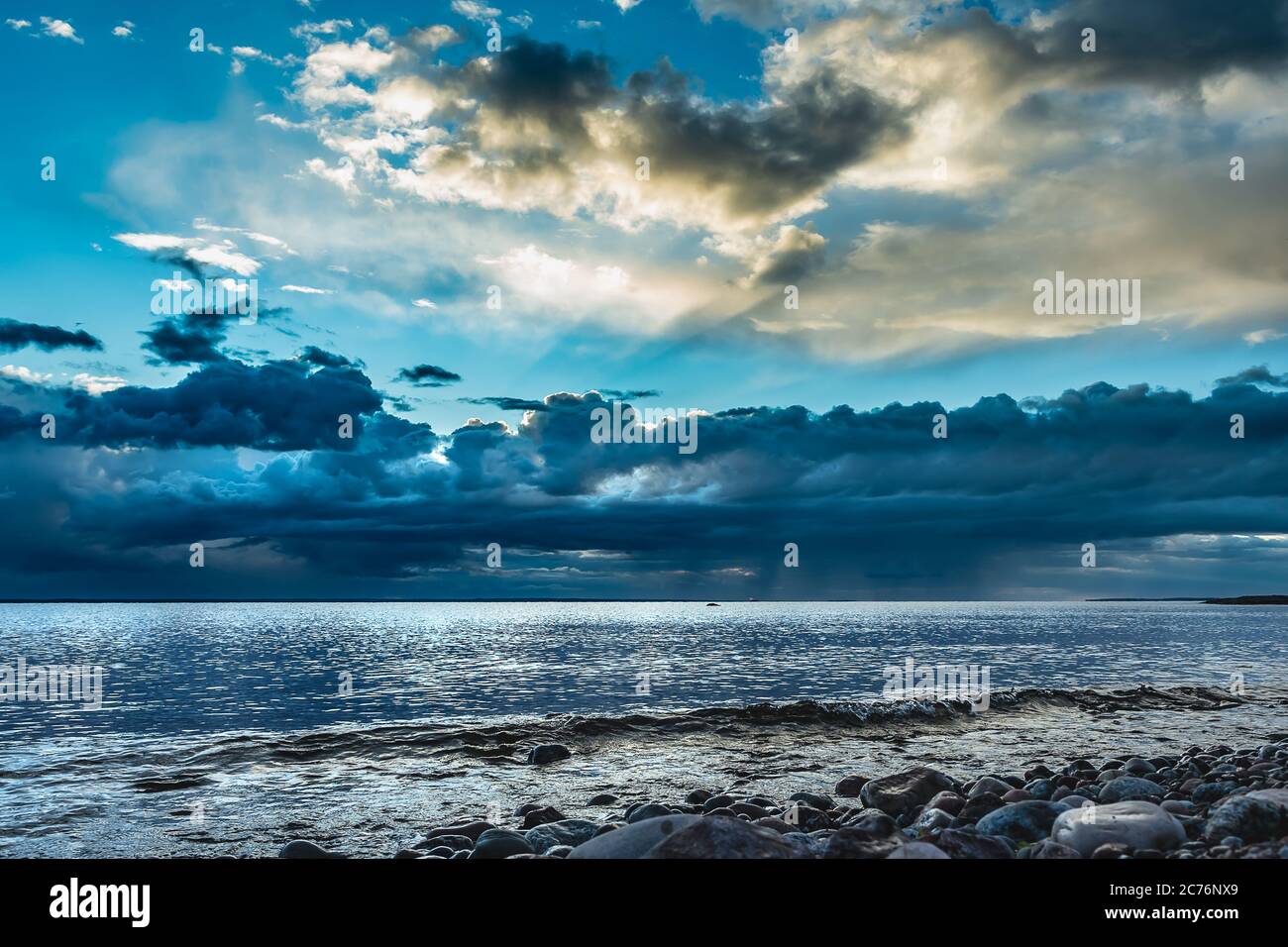 Il mare dopo una tempesta sul Mar Baltico svedese al tramonto dove i raggi del sole si illuminano tra le nuvole e il cielo comincia a ridirarsi blu Foto Stock