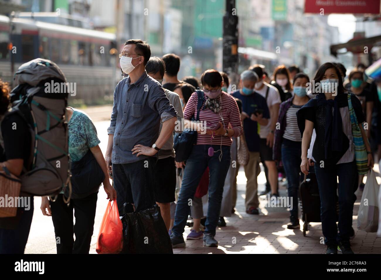 Hong Kong, Cina. 27 Marzo 2020. La gente si accoda alla fermata dell'autobus mentre indossa maschere facciali durante la pandemia del coronavirus.il governo ha inasprito la misura di distanza sociale come la città riporta 52 (uno dei più alti quotidiani) nuovi casi di coronavirus. Credit: May James/SOPA Images/ZUMA Wire/Alamy Live News Foto Stock