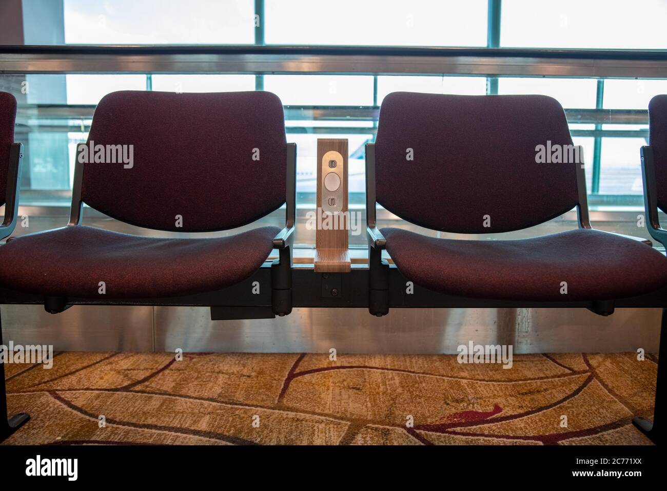 Sedie viola con presa di alimentazione USB standard gratuita o caricabatteria con slot per porta USB in aeroporto. Comfort di viaggio Foto Stock