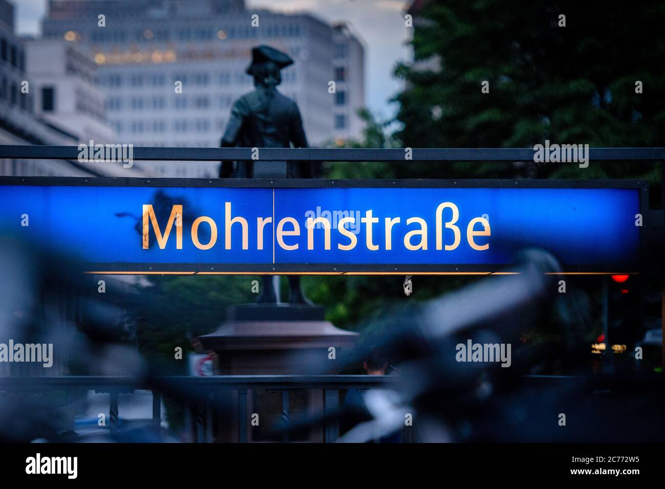 14 luglio 2020, Berlino, Berlino, Germania: L'ingresso della stazione della metropolitana 'Mohrenstrasse' si trova di fronte ad una statua. Dagli anni '90 a Berlino si discute di una nuova denominazione della 'Mohrenstrasse' e della stazione della metropolitana omonima, nel contesto di un dibattito più ampio sui nomi delle strade che possono essere storicamente accusati. 'mohr' è un termine di discriminazione di lingua tedesca obsoleta per le persone di colore. Nel luglio 2020, la compagnia di trasporti pubblici di Berlino BVG ha deciso di rinominare la stazione della metropolitana "ohrenstraÃŸe". Anche il nuovo nome originale ''GlinkastraÃŸe'' è stato eliminato Foto Stock