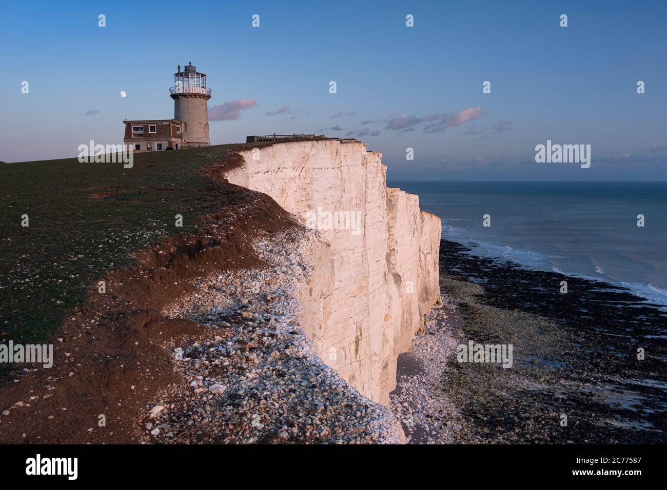 Moonrise sopra Belle Tout Lighthouse al tramonto, Beachy Head, vicino a Eastbourne, South Downs National Park, East Sussex, Inghilterra, Regno Unito Foto Stock