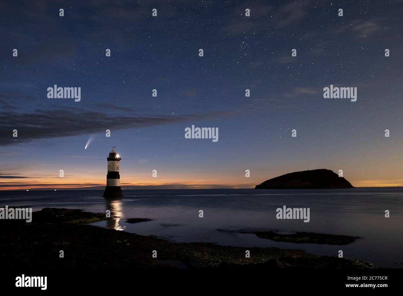 Comet NEOWISE e il cielo notturno sopra Trwyn Du Lighthouse e Puffin Island, Penmon, Anglesey, Galles del Nord, Regno Unito Foto Stock