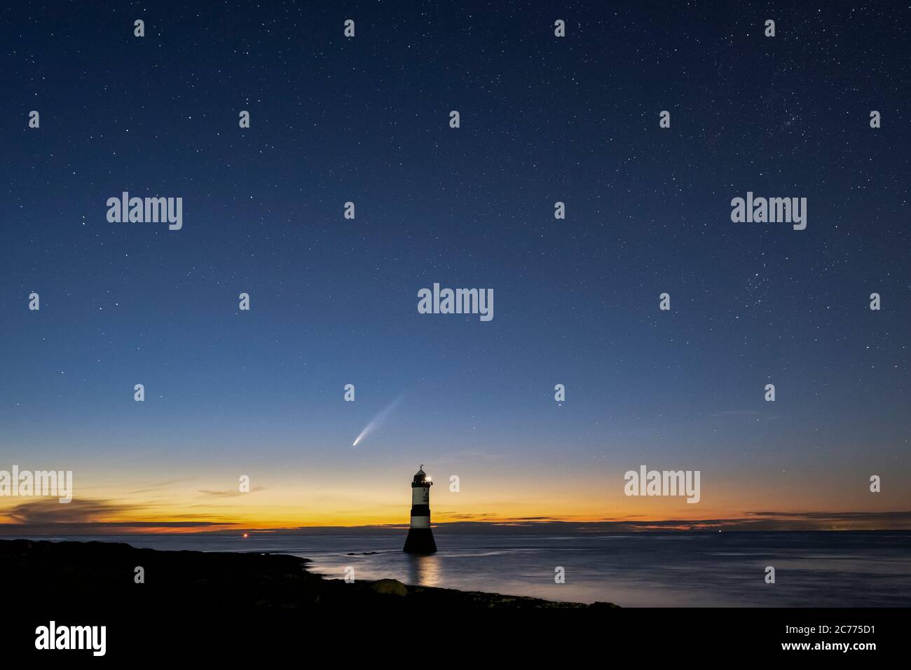 Comet NEOWISE e il cielo notturno sopra Trwyn Du Lighthouse o Penmon Point Lighthouse, Penmon, Anglesey, Galles del Nord, Regno Unito Foto Stock